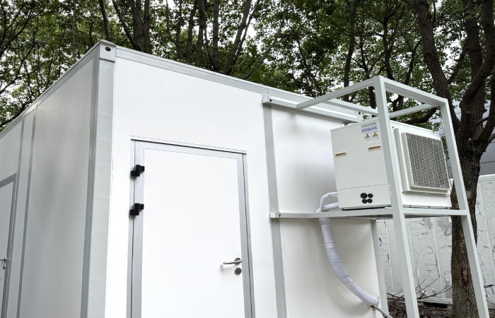 Exterior of a container laboratory module with cleanroom door and dedicated HVAC condenser platform