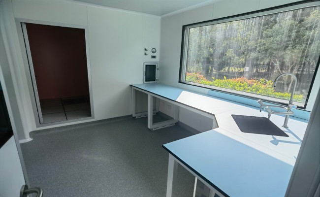 Modular cleanroom interior with clean wall panels workbench sink and pass-through window